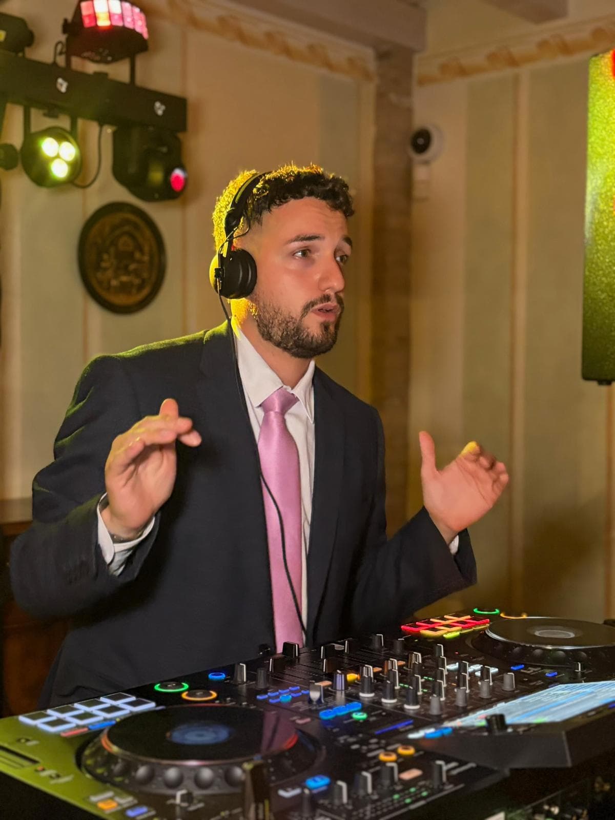 Luca Paone in giacca e cuffie alla console in una sala da matrimonio